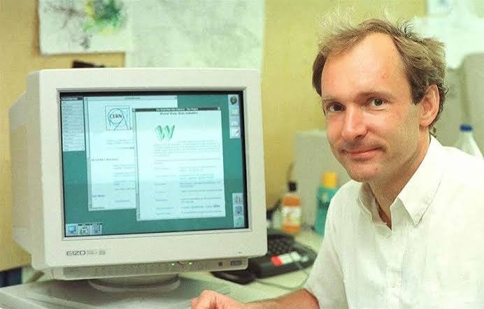 Tim Berners-Lee at CERN in the early 1990s, beside the equipment used to run the first web server